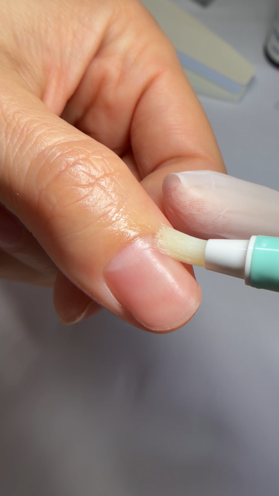 Pflegeöl wird auf die Nagelhaut aufgetragen