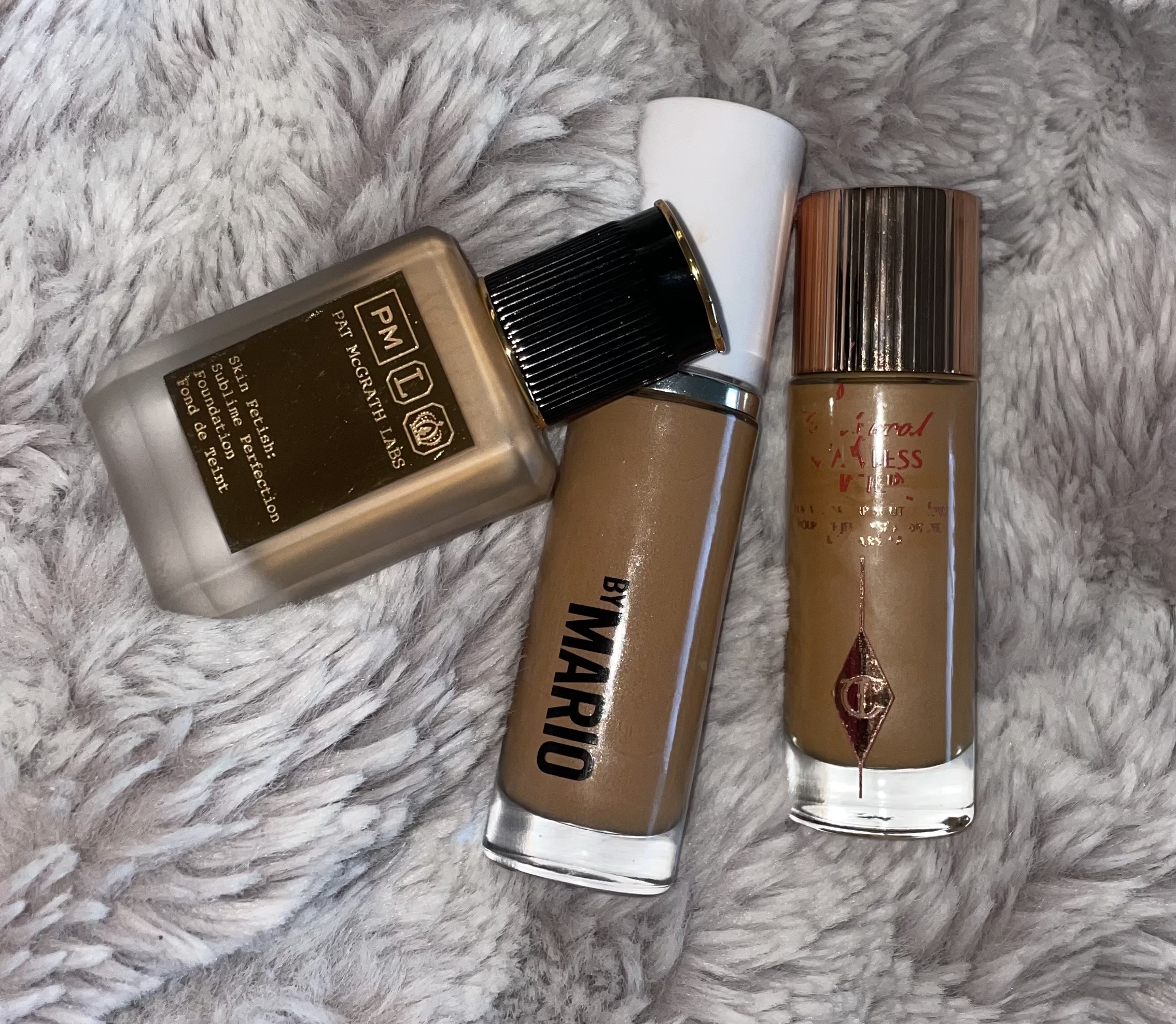 Foundations in multiple shades on a gray faux-fur background, illustrating how makeup shades shift between winter and summer seasons.