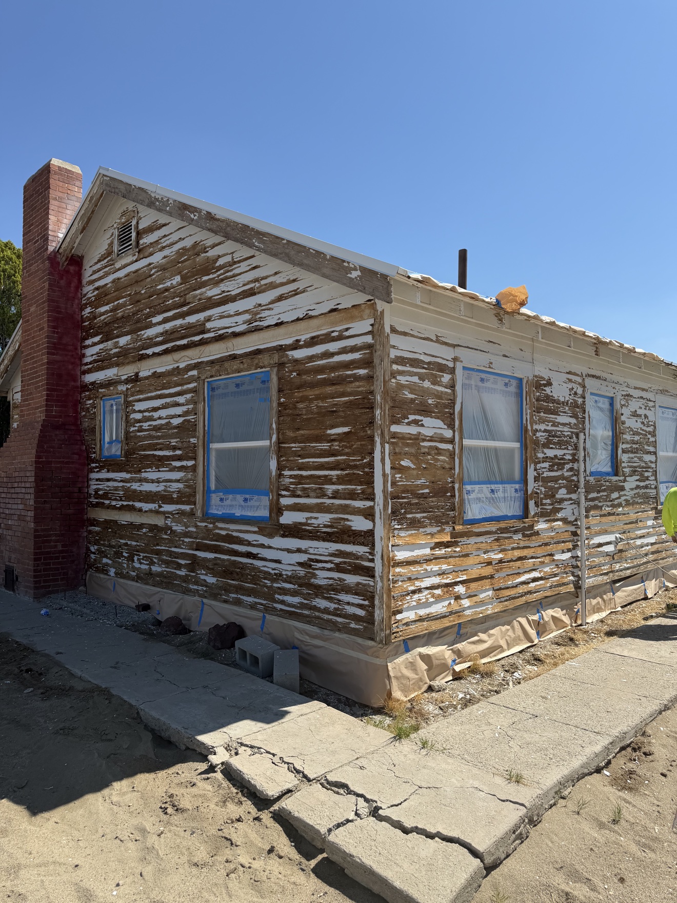 Exterior before repaint — long side, paint failed to bare wood