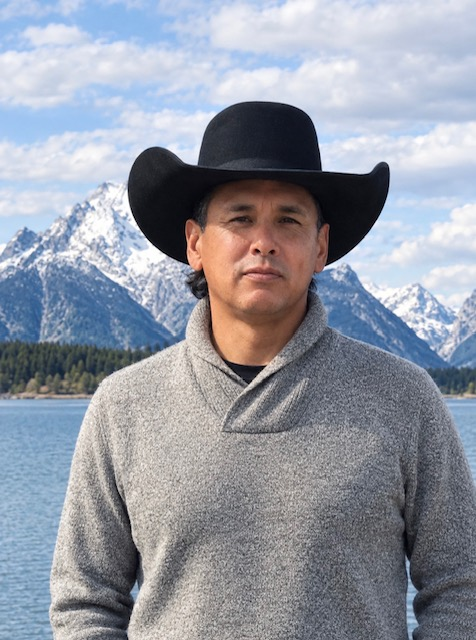 Shawn Miller in a black felt hat with the Grand Tetons and Jenny Lake behind him