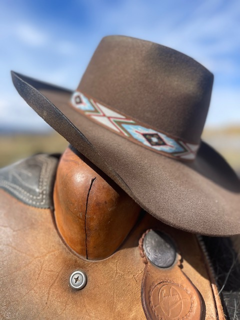 Beaded hatband detail on a brown felt hat