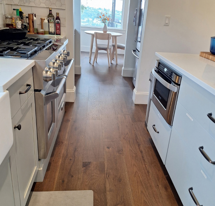 Bright, clean Seattle kitchen with wooden floors and white cabinets
