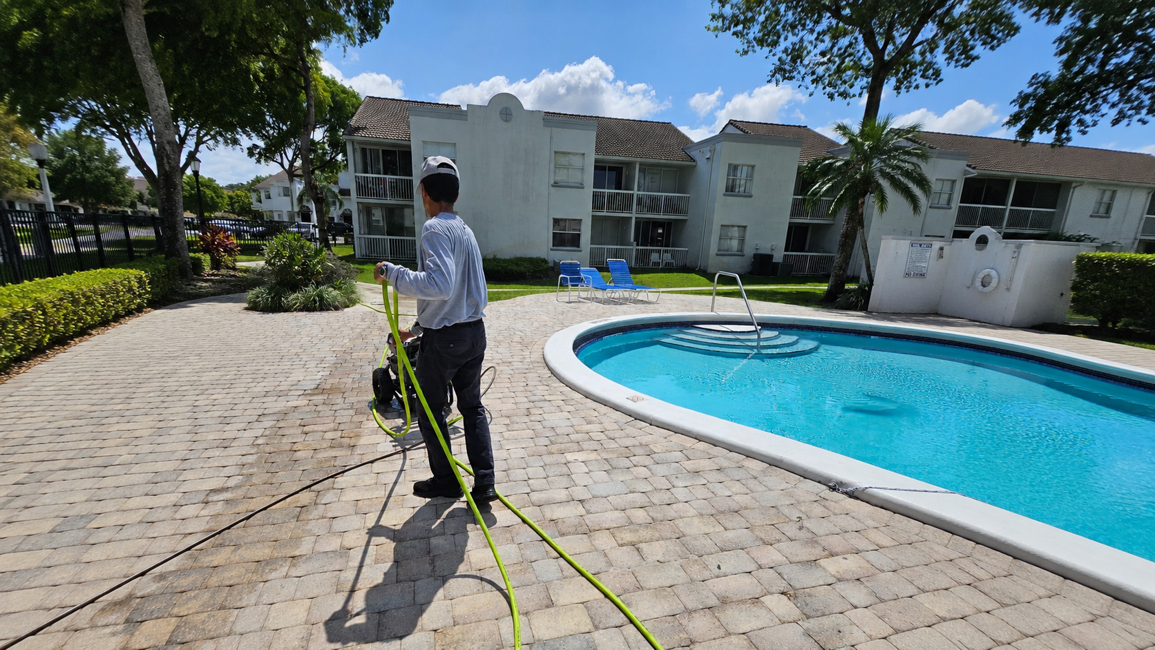 Spertex technician sealing a pool deck with pavers in South Florida