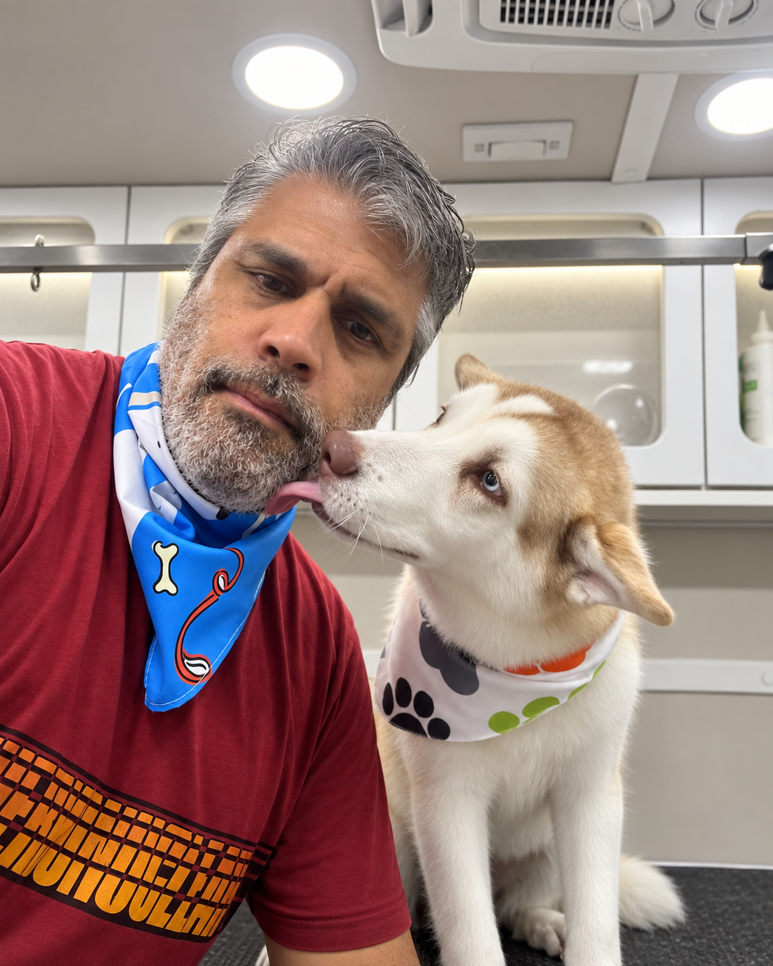 Oscar groomer giving an affectionate kiss to a happy client dog