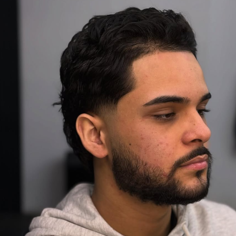 Taper fade with wavy textured top and beard