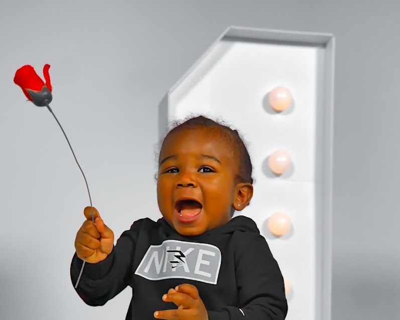 Little boy holding a red rose during a Dream baby portrait session at 757 Dream Lab Studio