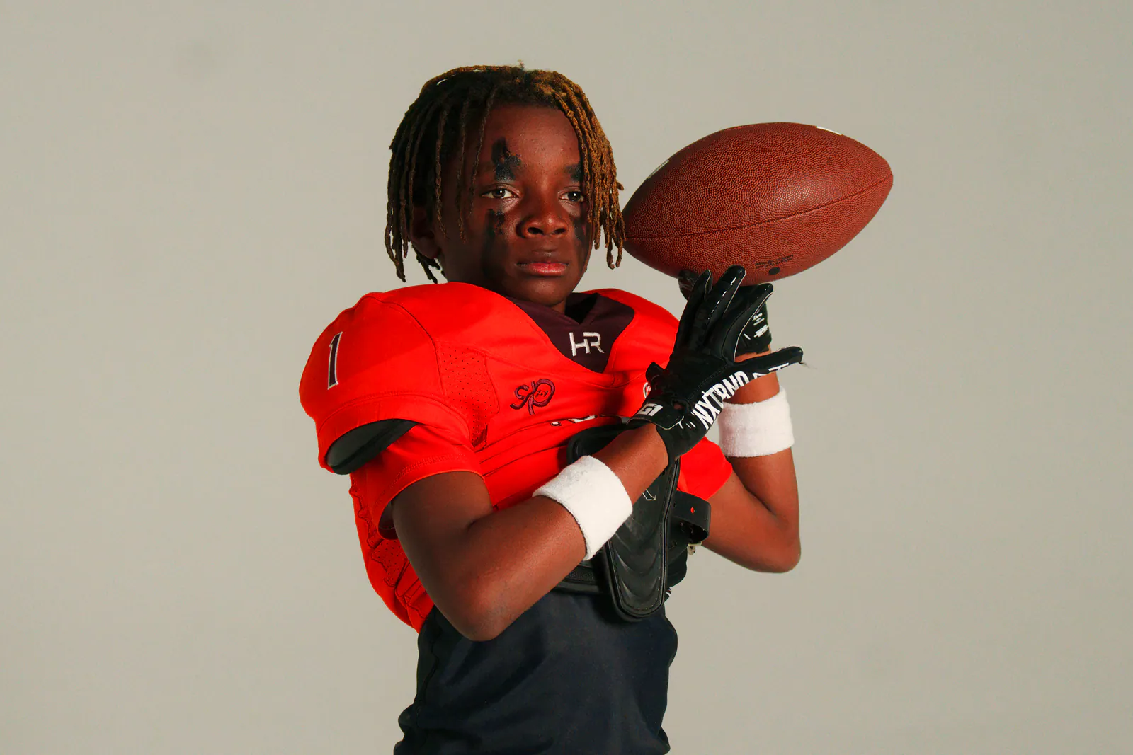 Football athlete in red uniform with ball at 757 Dream Lab Studio