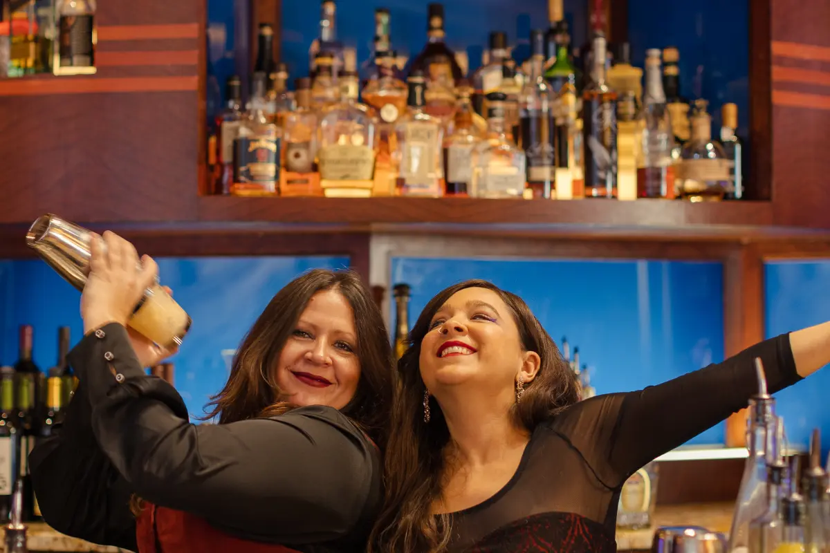 Bars on Wheels bartenders shaking cocktails while entertaining guests at lively private party bar setup