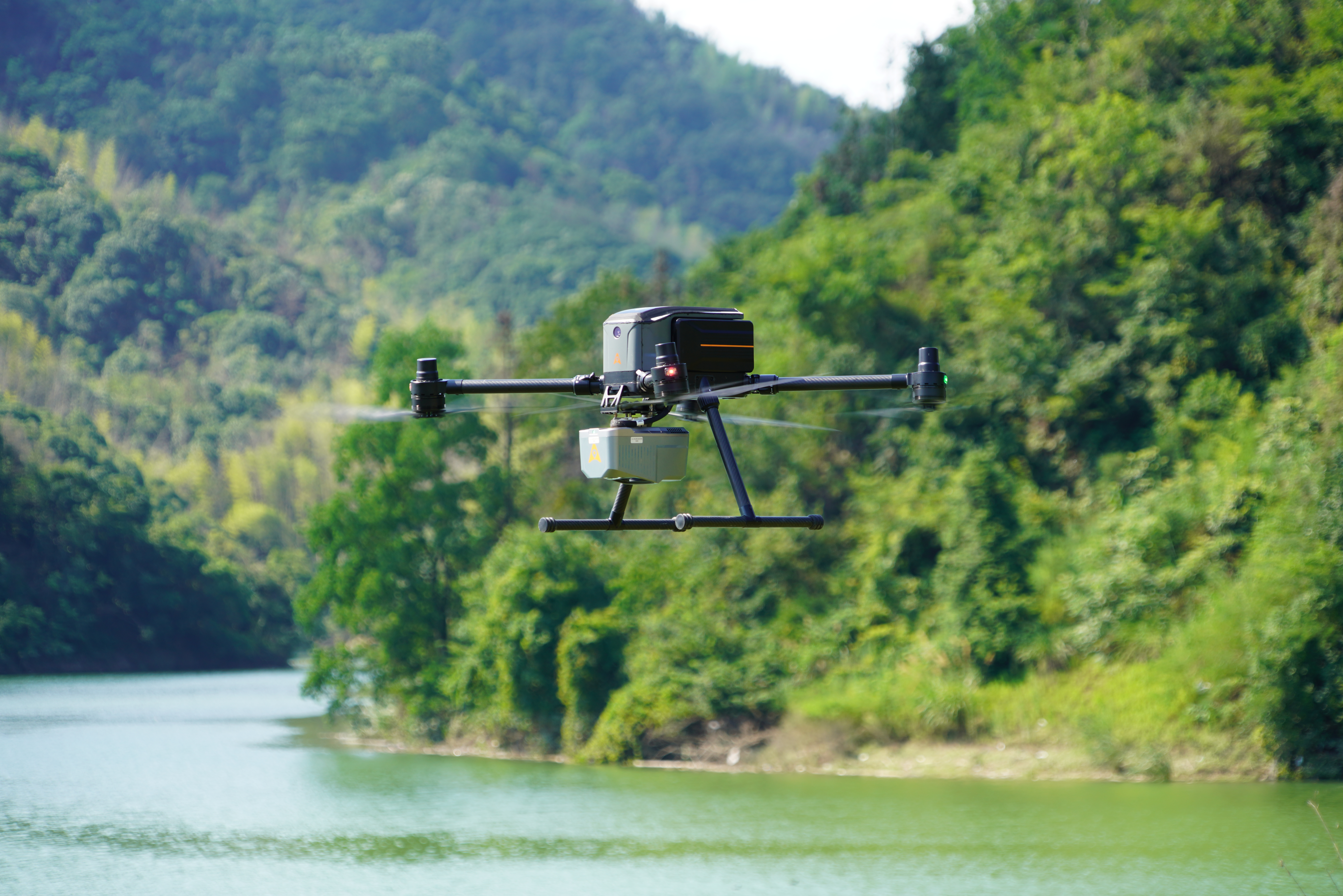 CHCNAV X500 carrying an AlphaAir LiDAR payload over wooded terrain