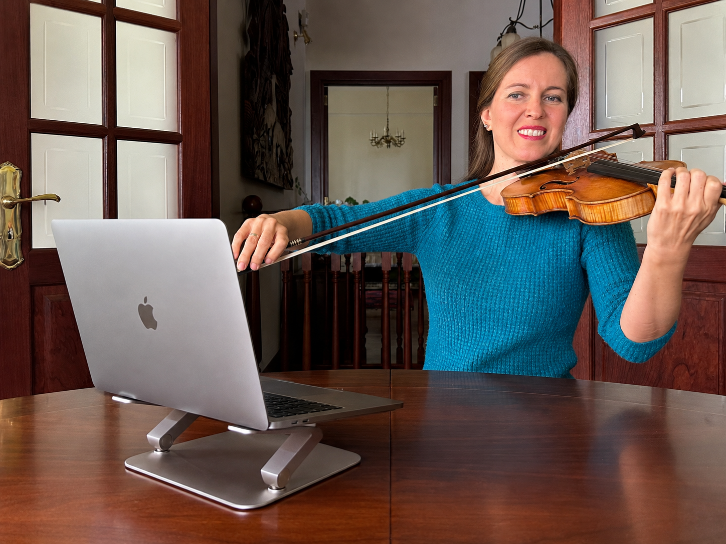 Maite teaching violin online beside a laptop