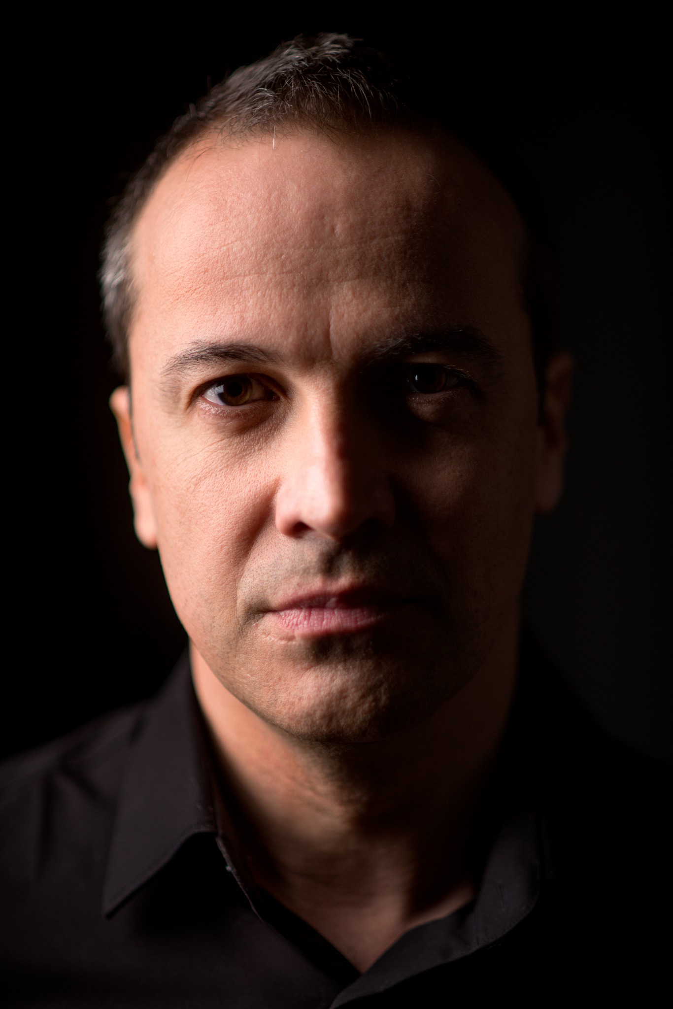 Portrait of Cristo Barrios against a black background