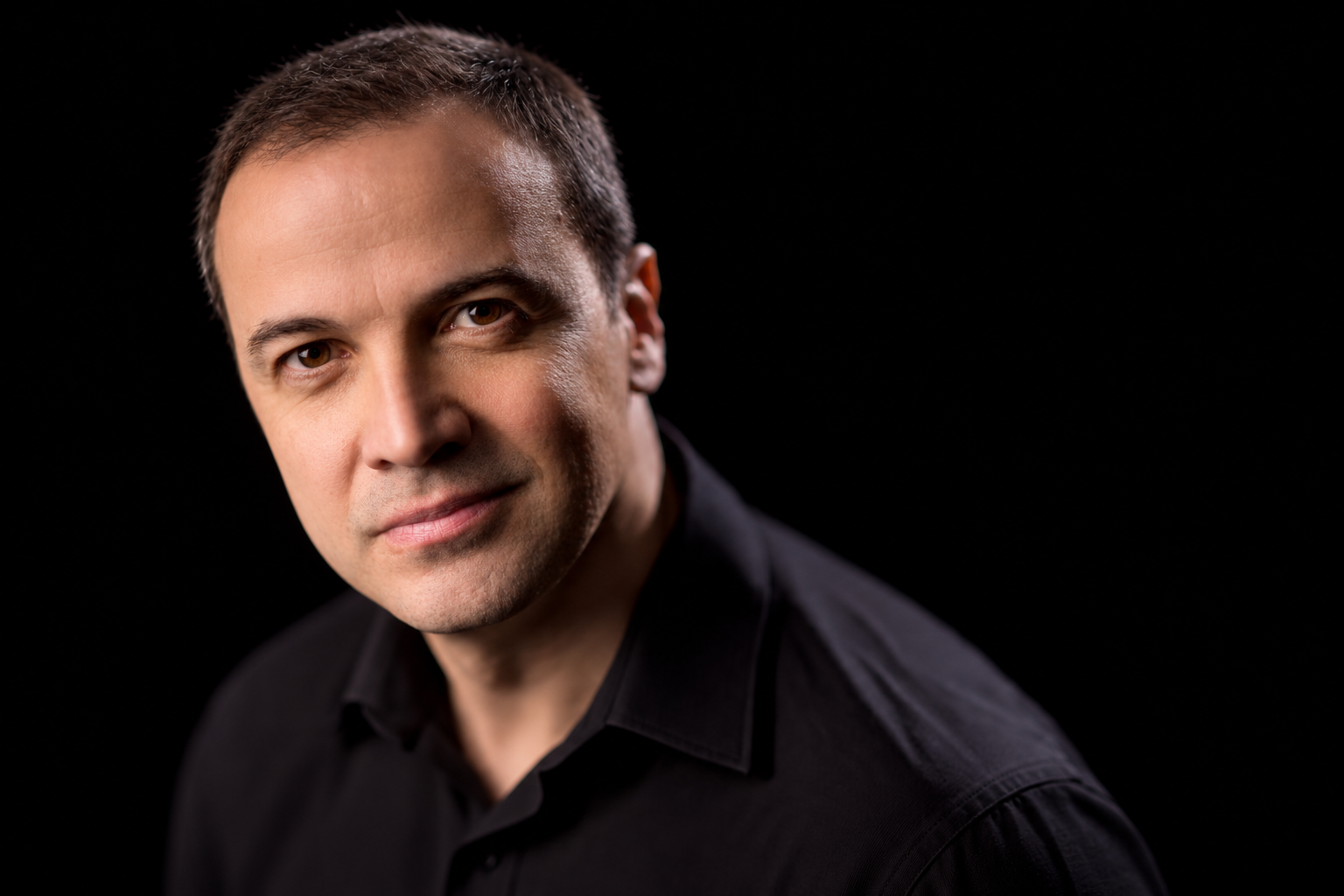 Portrait of Cristo Barrios against a black background