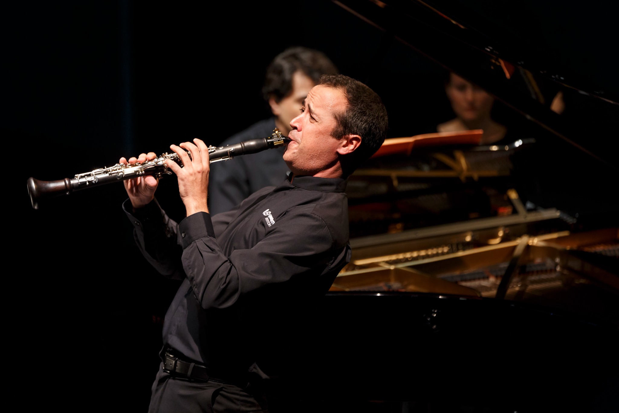 Cristo Barrios performing on clarinet beside a piano