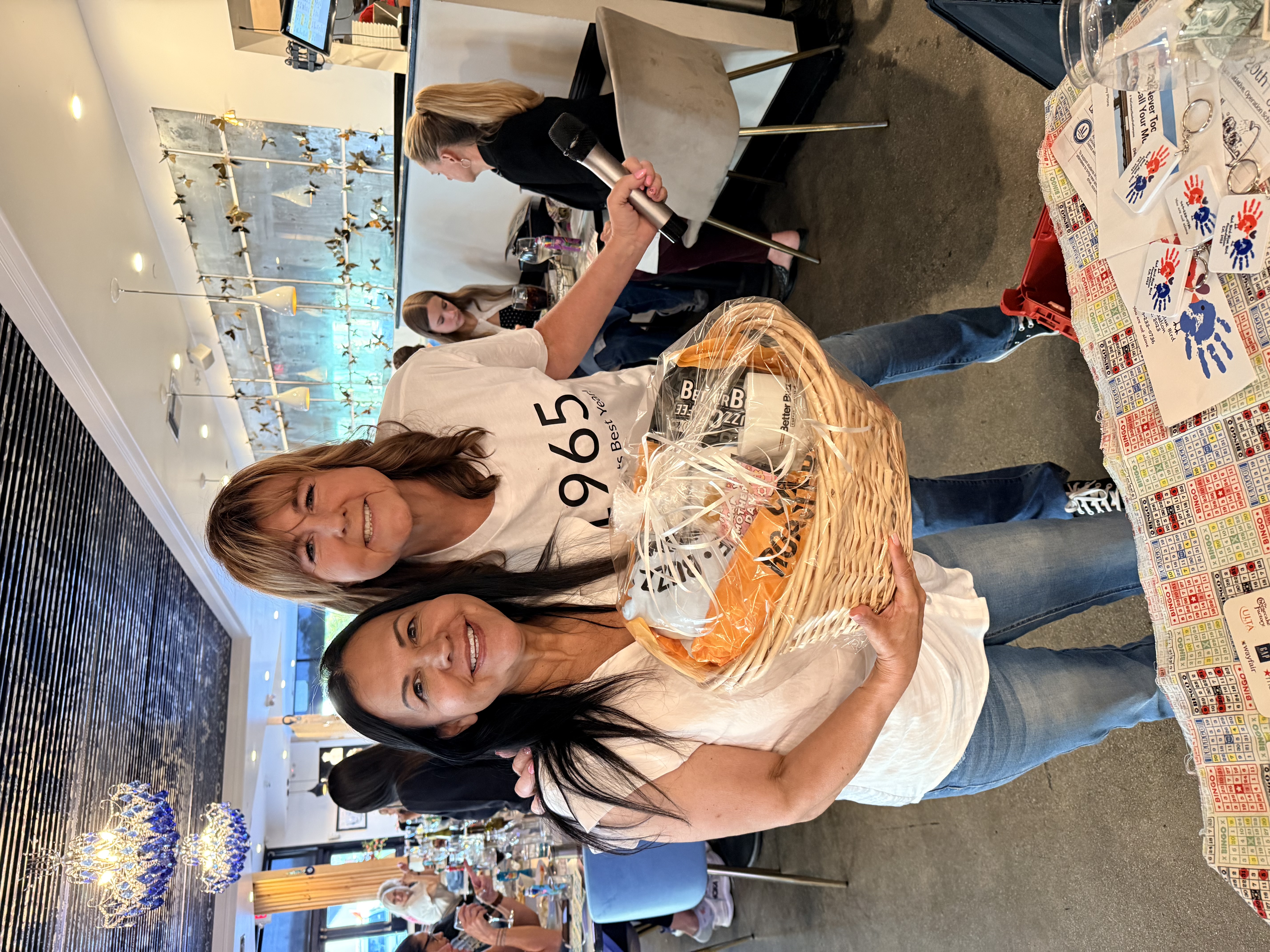 Kim with a Bingo winner holding a Mother's Day gift basket