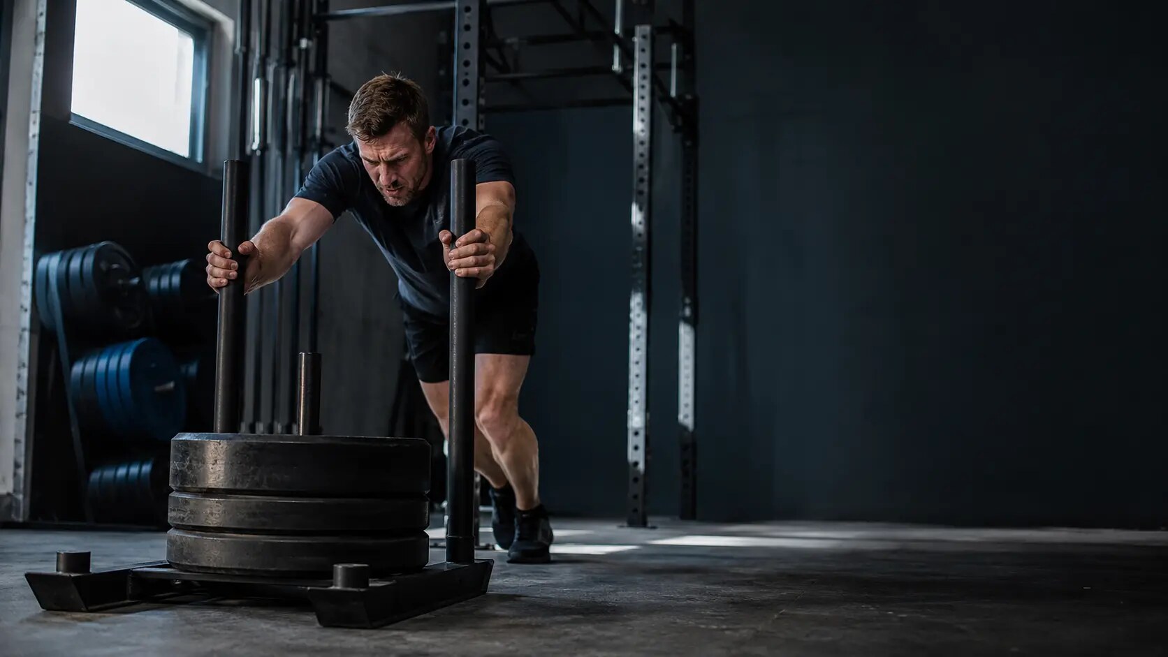 Woman performing a barbell deadlift in a strength gym