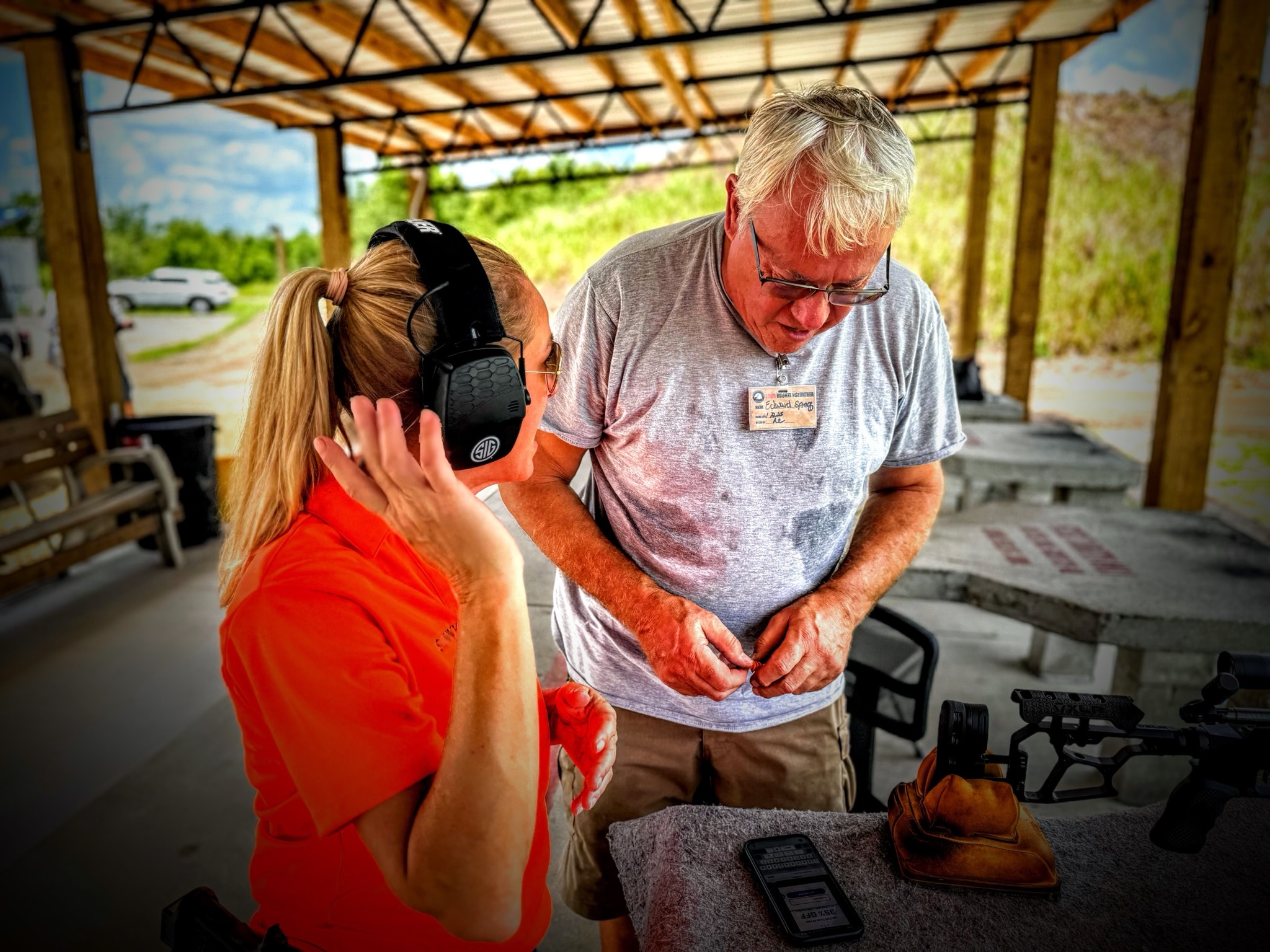 Range Safety Officer fitting hearing protection on a first-time shooter at MGAC