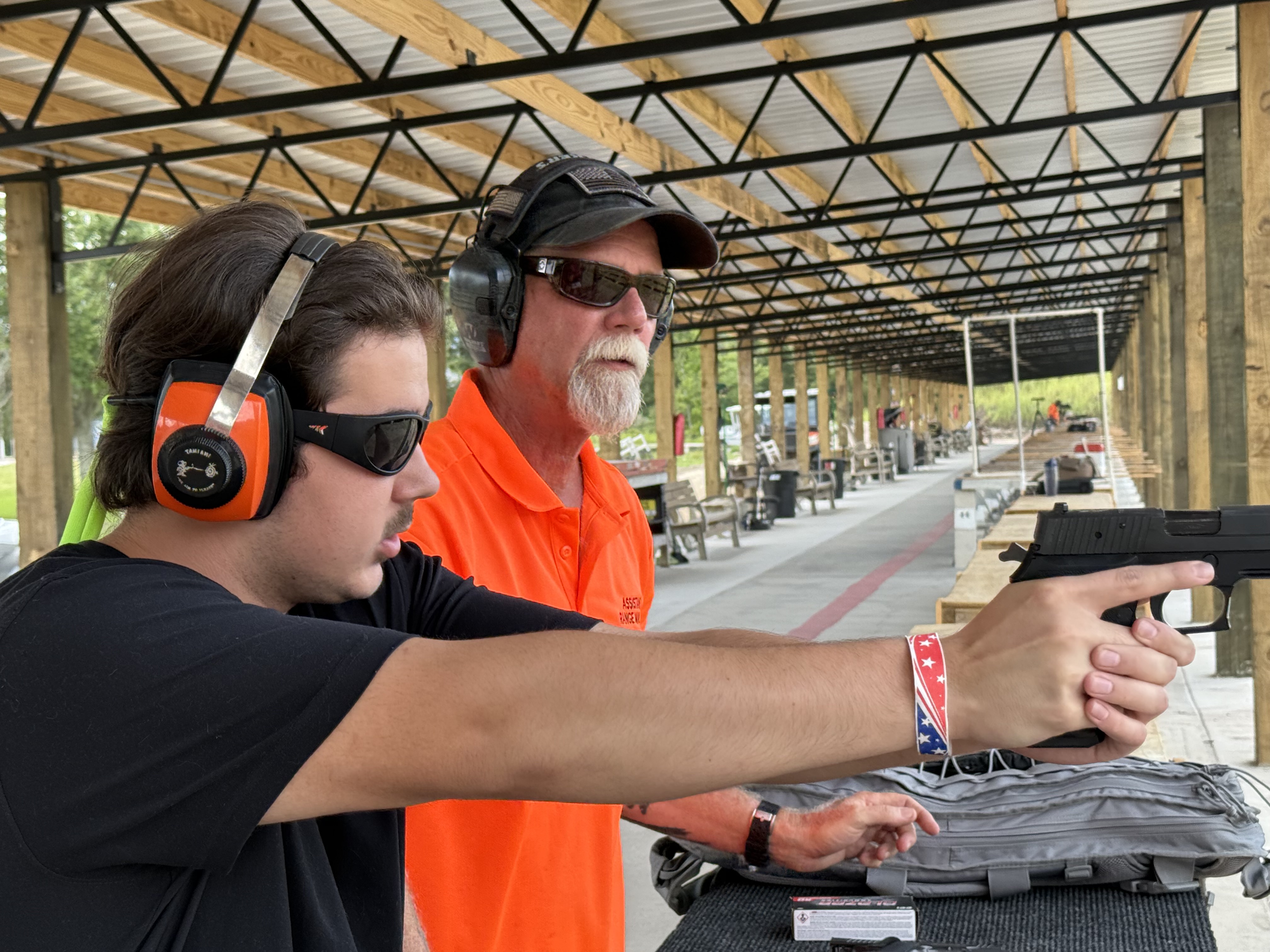 New shooter learning pistol fundamentals with an MGAC Range Safety Officer