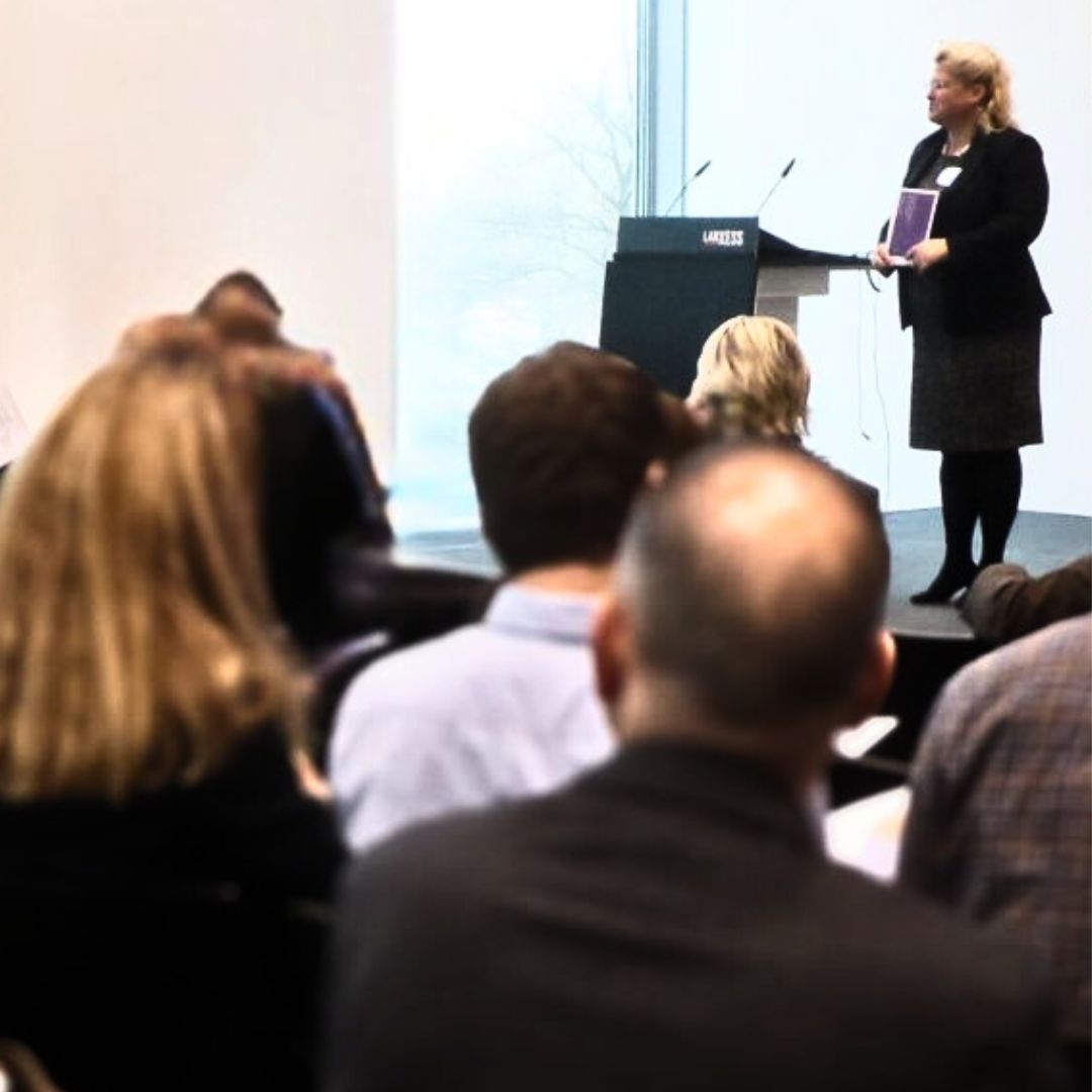 Birgit Gosejacob at the lectern, in front of audience