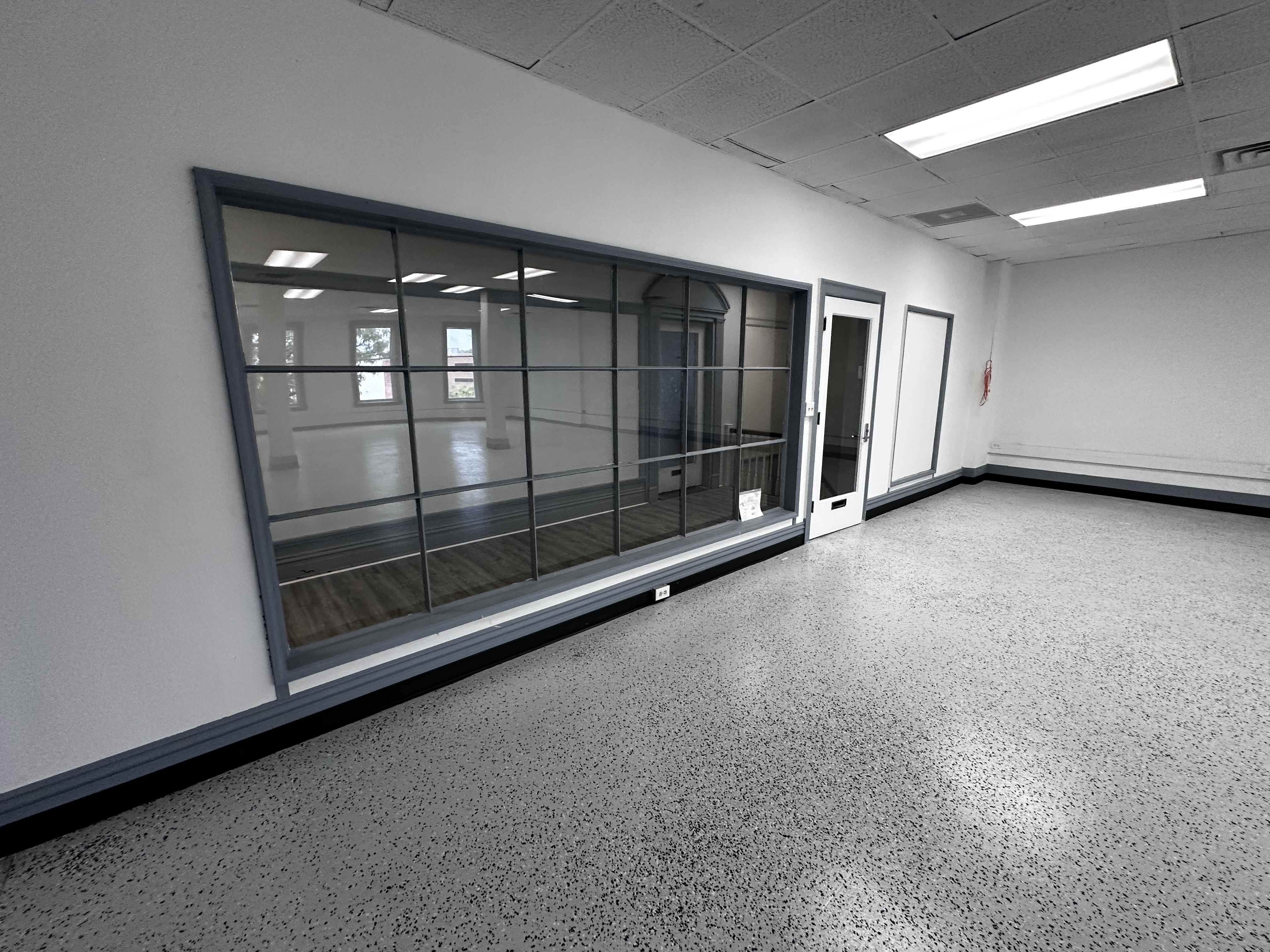 Suite 328 glass-paneled entry wall and door viewed from the third-floor hallway