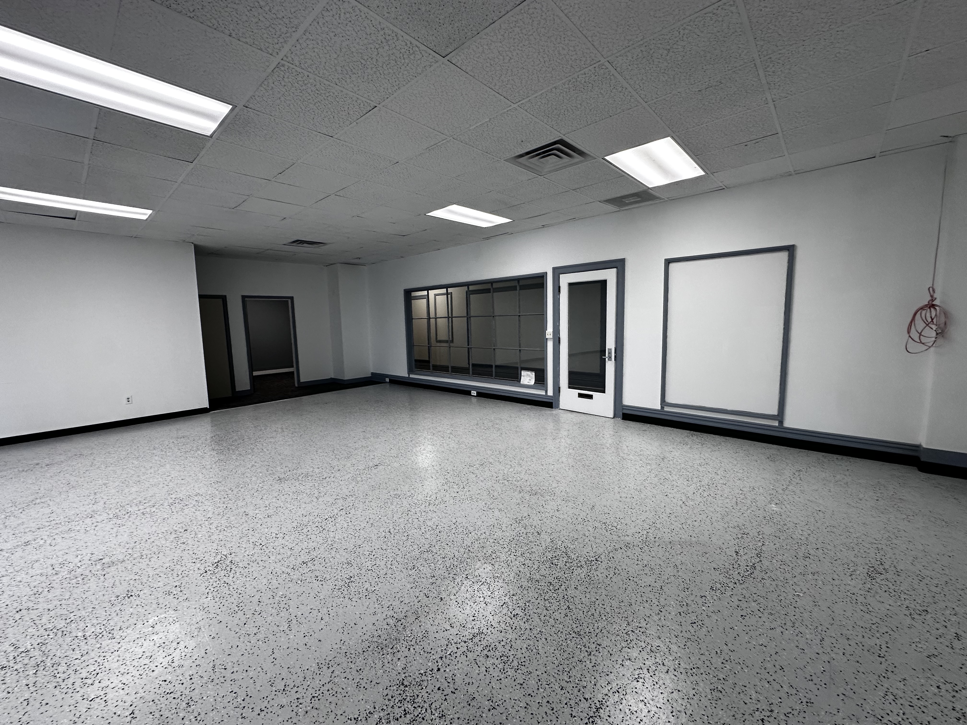 Suite 328 main room showing the glass entry wall and rear doors