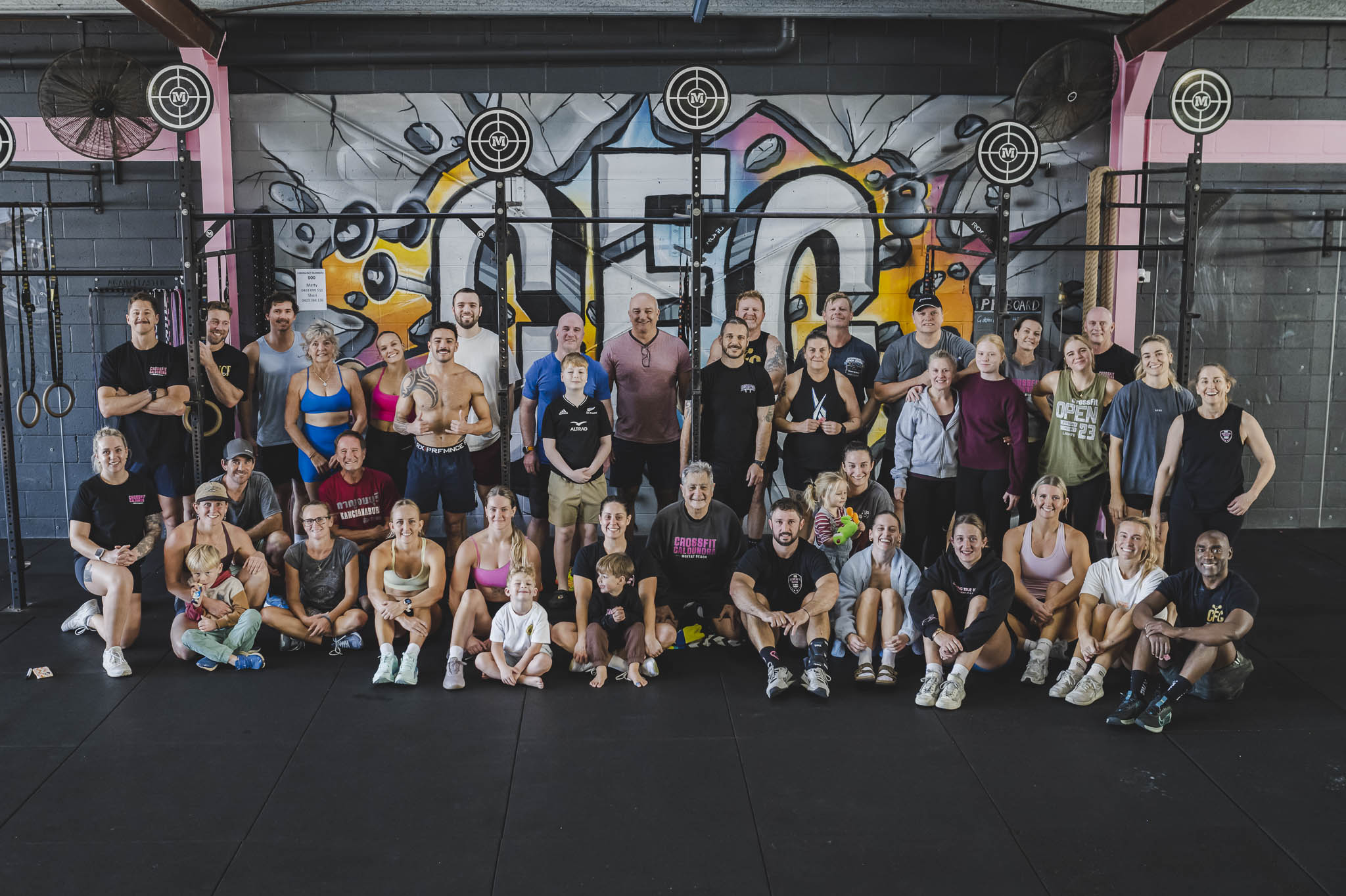 The CFC community in front of the gym mural