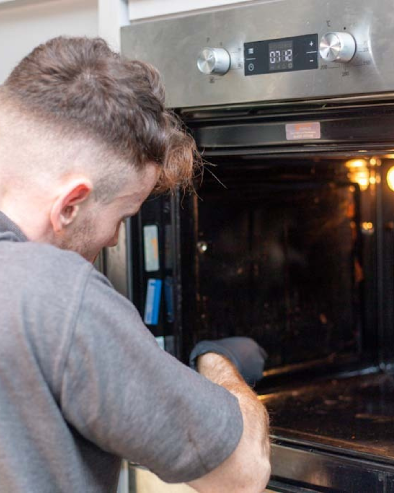 a technician cleaning a kitchen oven