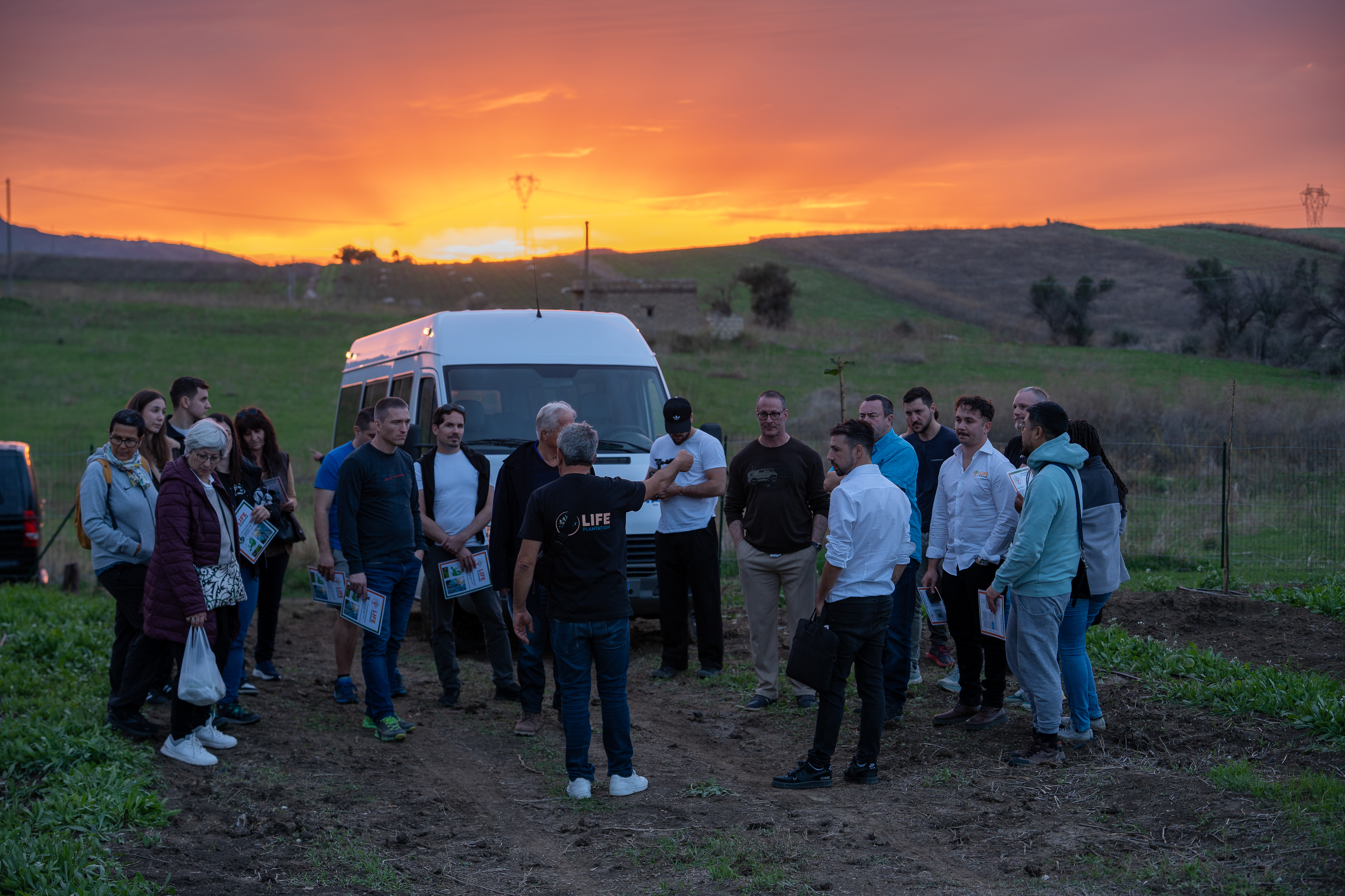 Groupe de visiteurs lors dâune rencontre sur les terrains de plantation au coucher du soleil