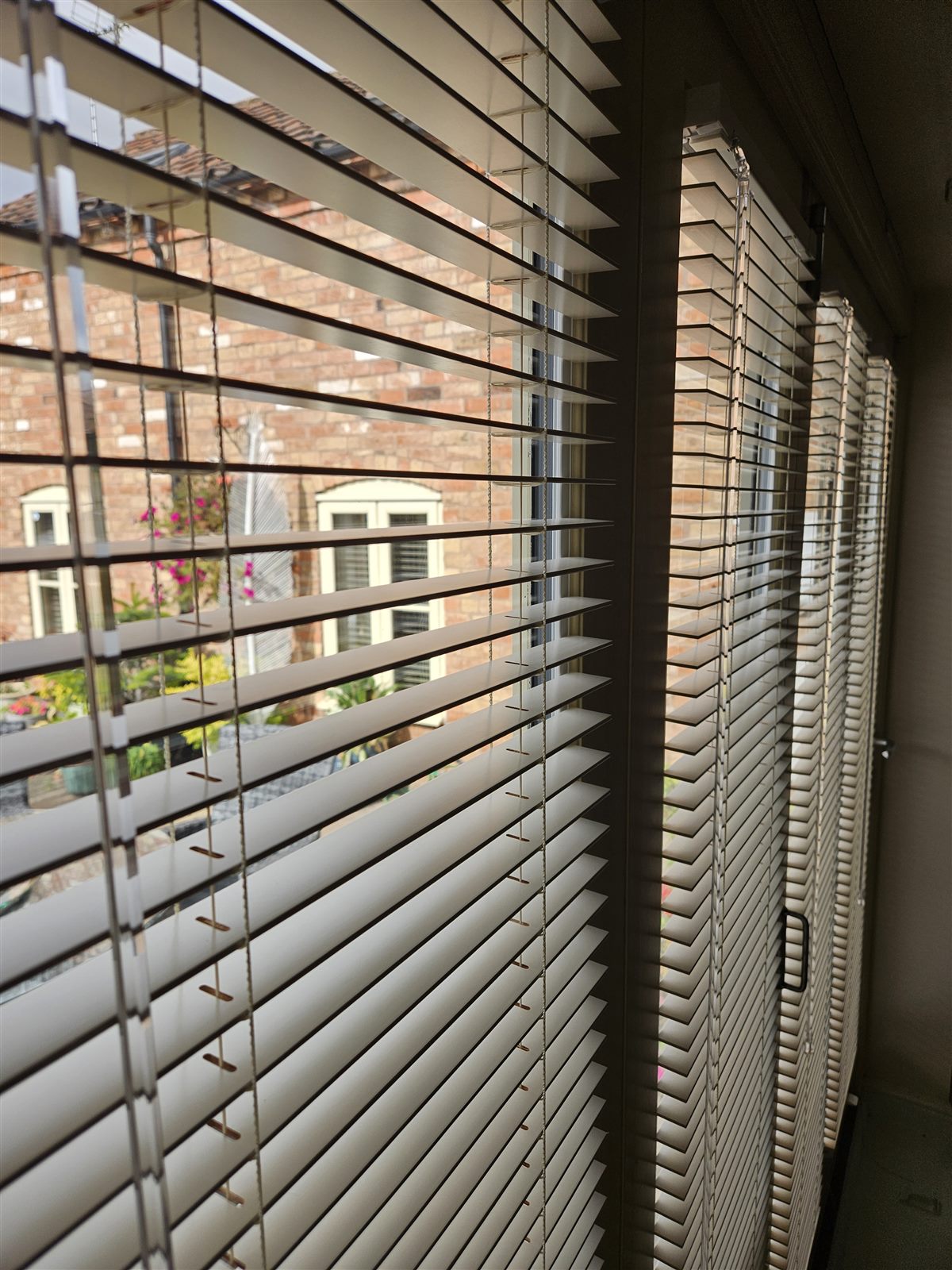 Cream real wood venetian blinds fitted to bi-fold doors by Eclipse SBC in Retford