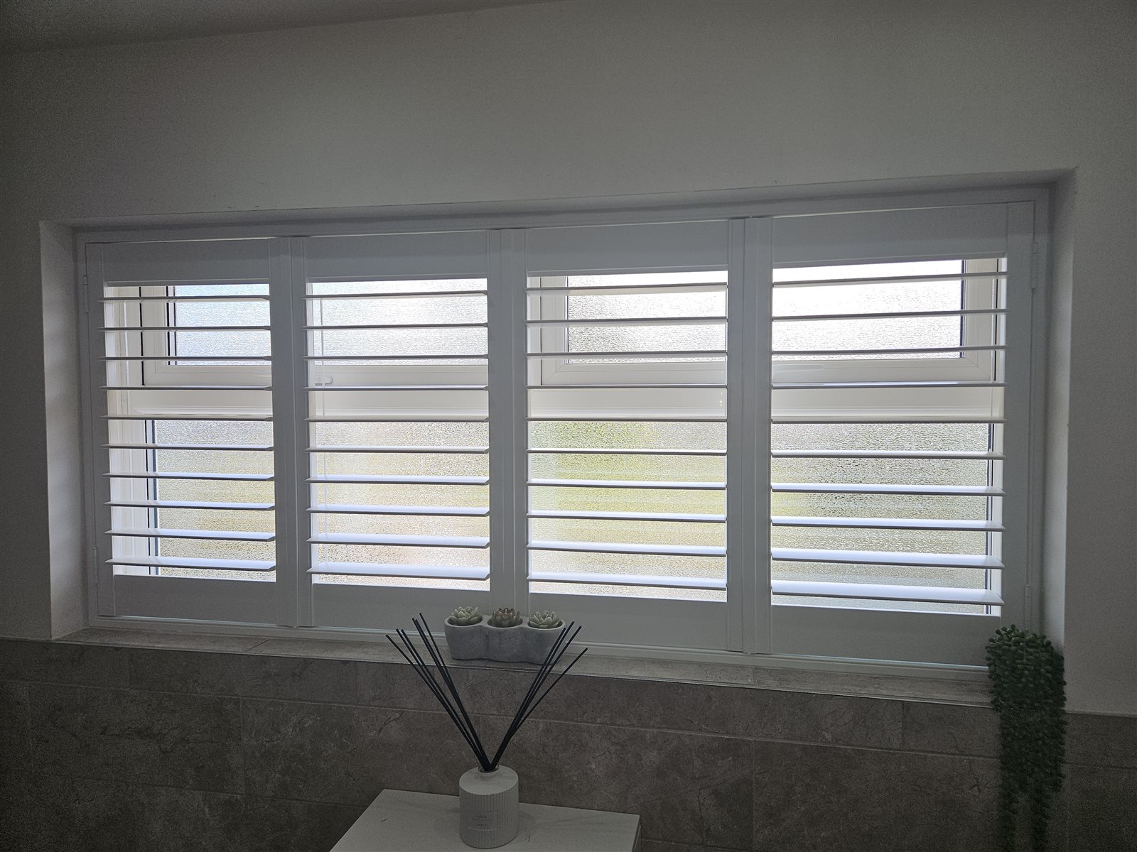 White Hampton polyvinyl plantation shutters on a bathroom window, fitted by Eclipse SBC in Retford