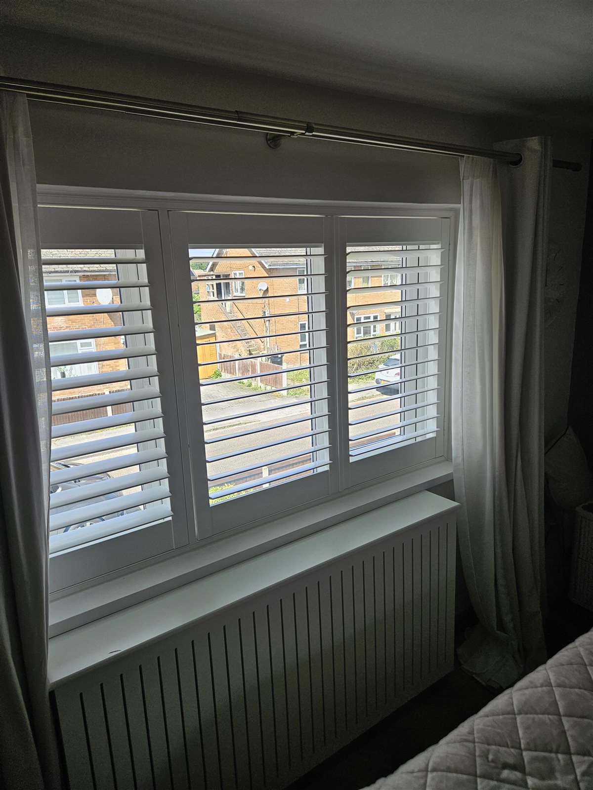 White plantation shutters in a bedroom with a panelled radiator cover, fitted by Eclipse SBC in Retford