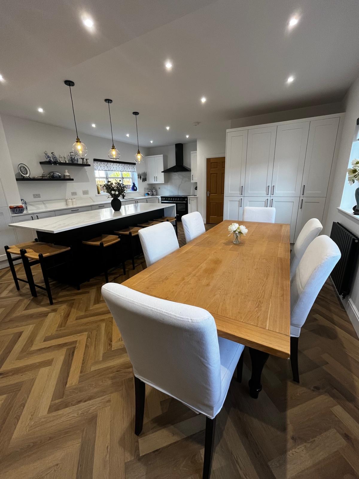Kitchen after: white shaker with island and herringbone floor