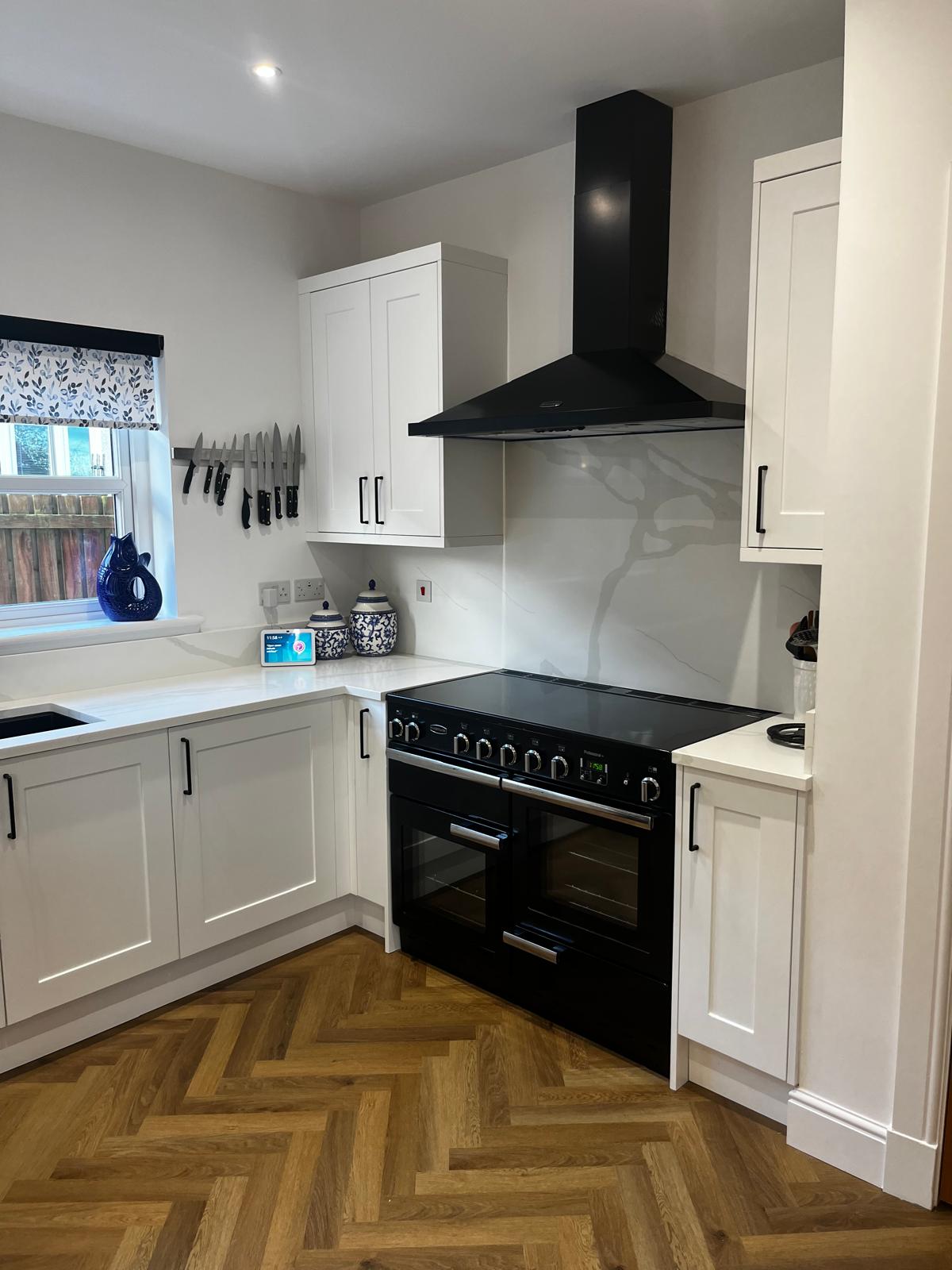 Finished white shaker kitchen with black range cooker