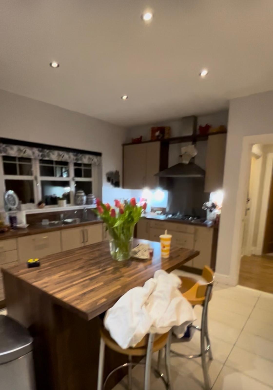 Kitchen before: dated cream doors and dark wood island