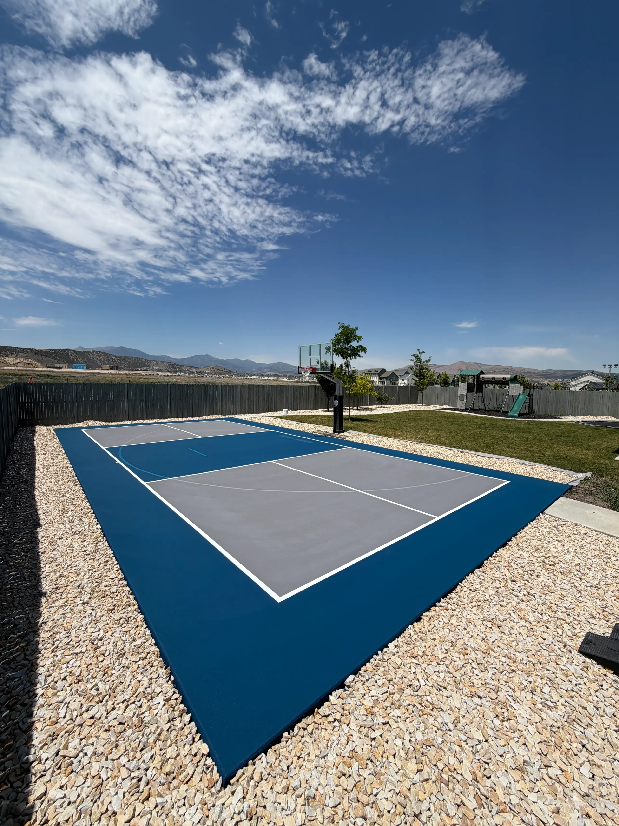 Navy and grey multicourt framed by white rock landscaping