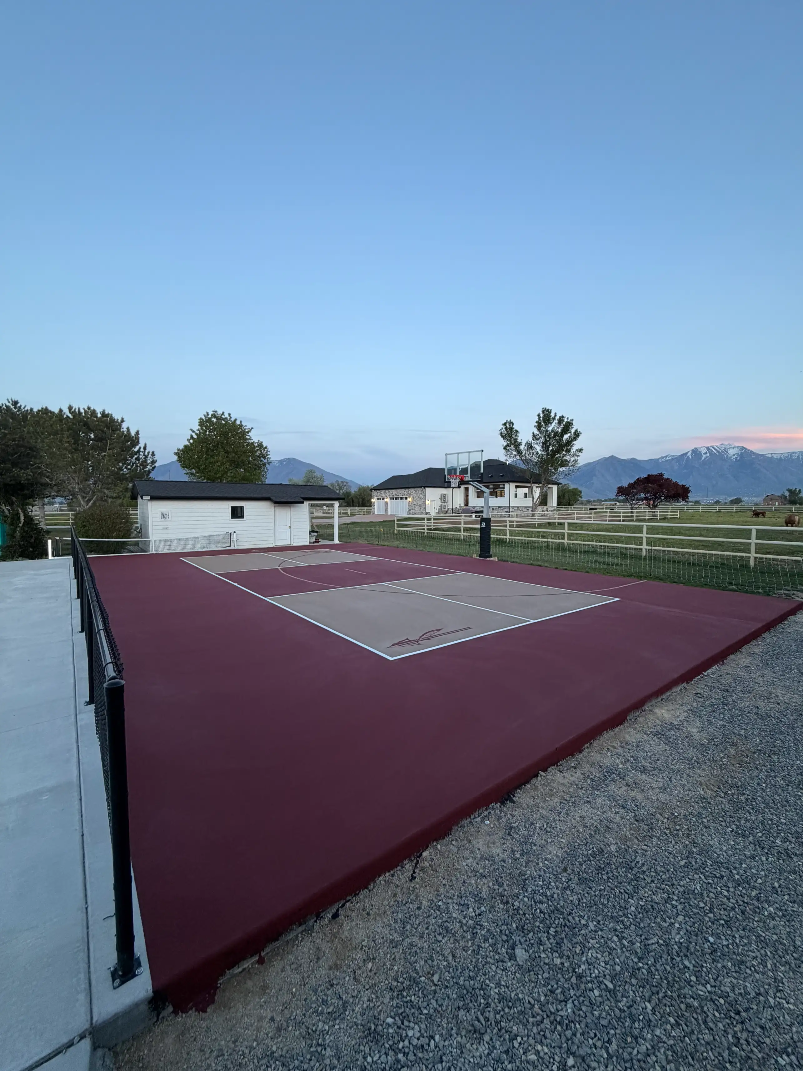 Maroon and tan multicourt with custom spear emblem and mountain view at dusk