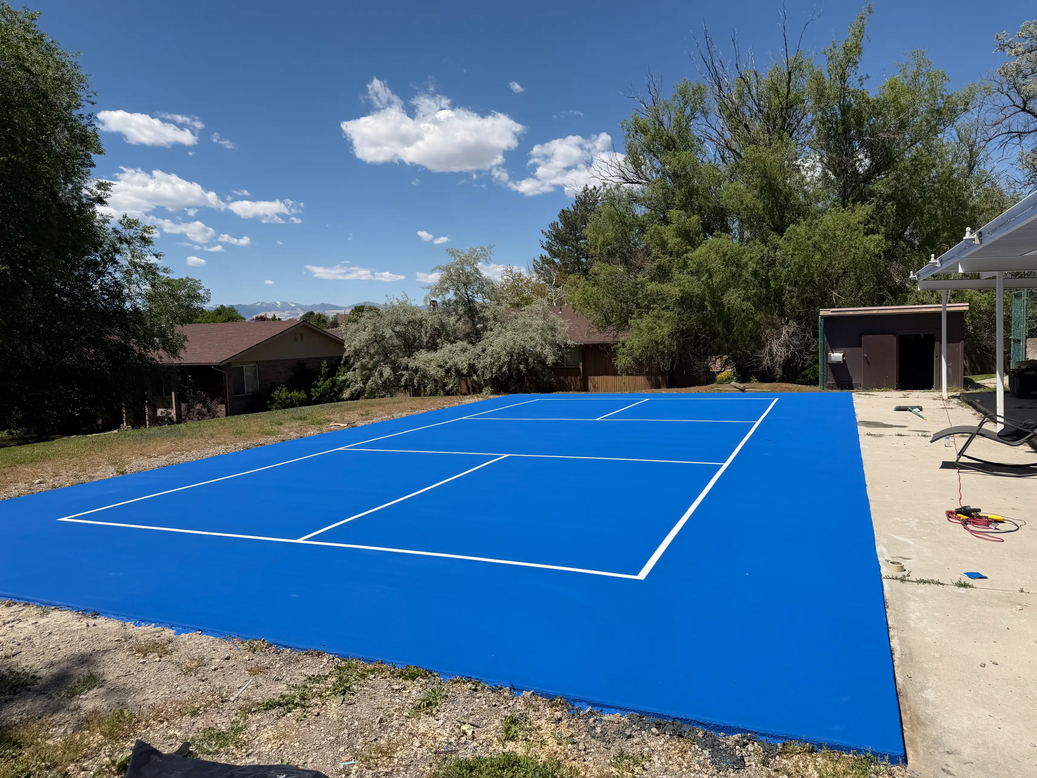 Freshly coated all-blue backyard pickleball court