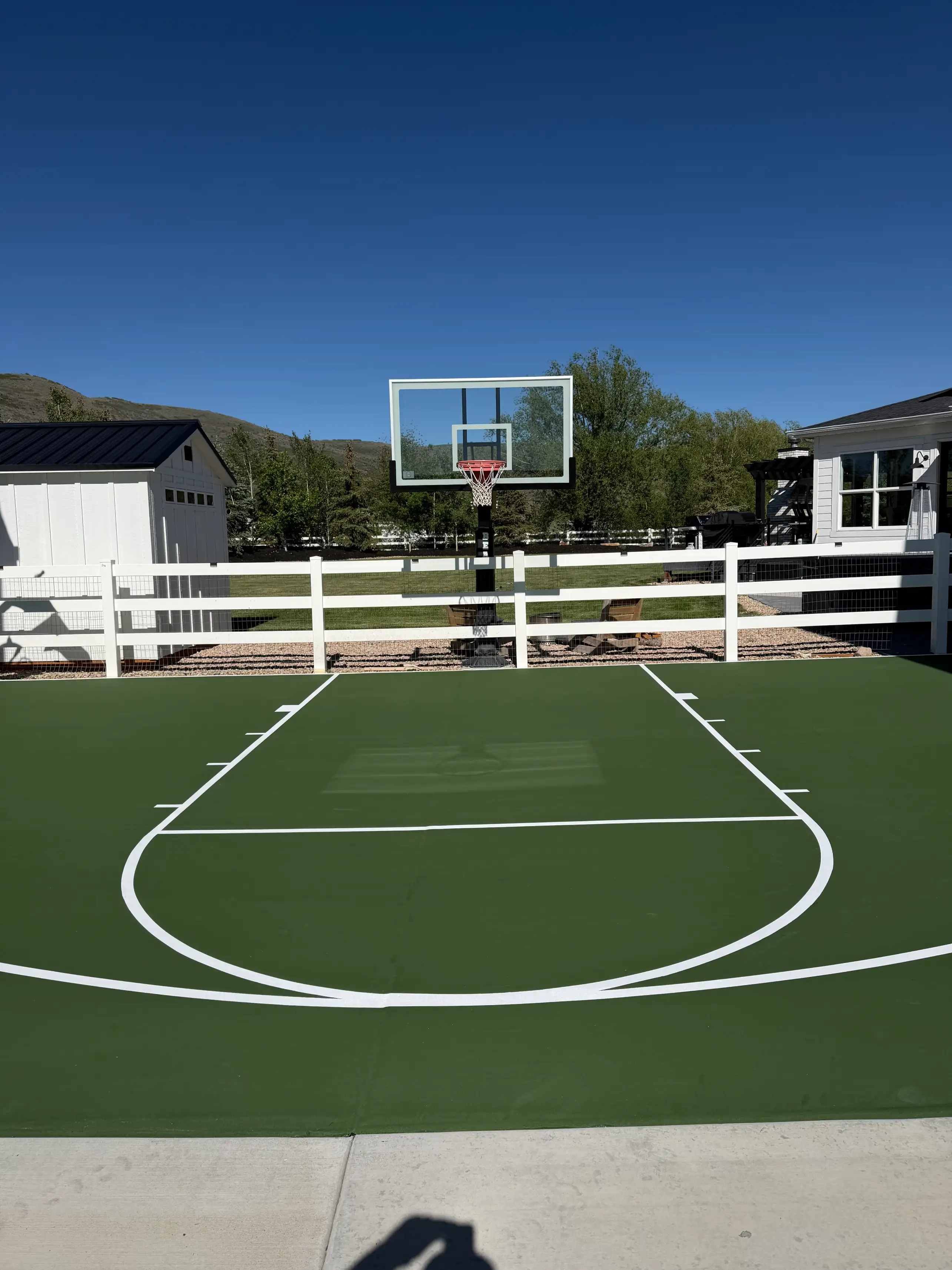 Forest green basketball half court with white farmhouse fencing