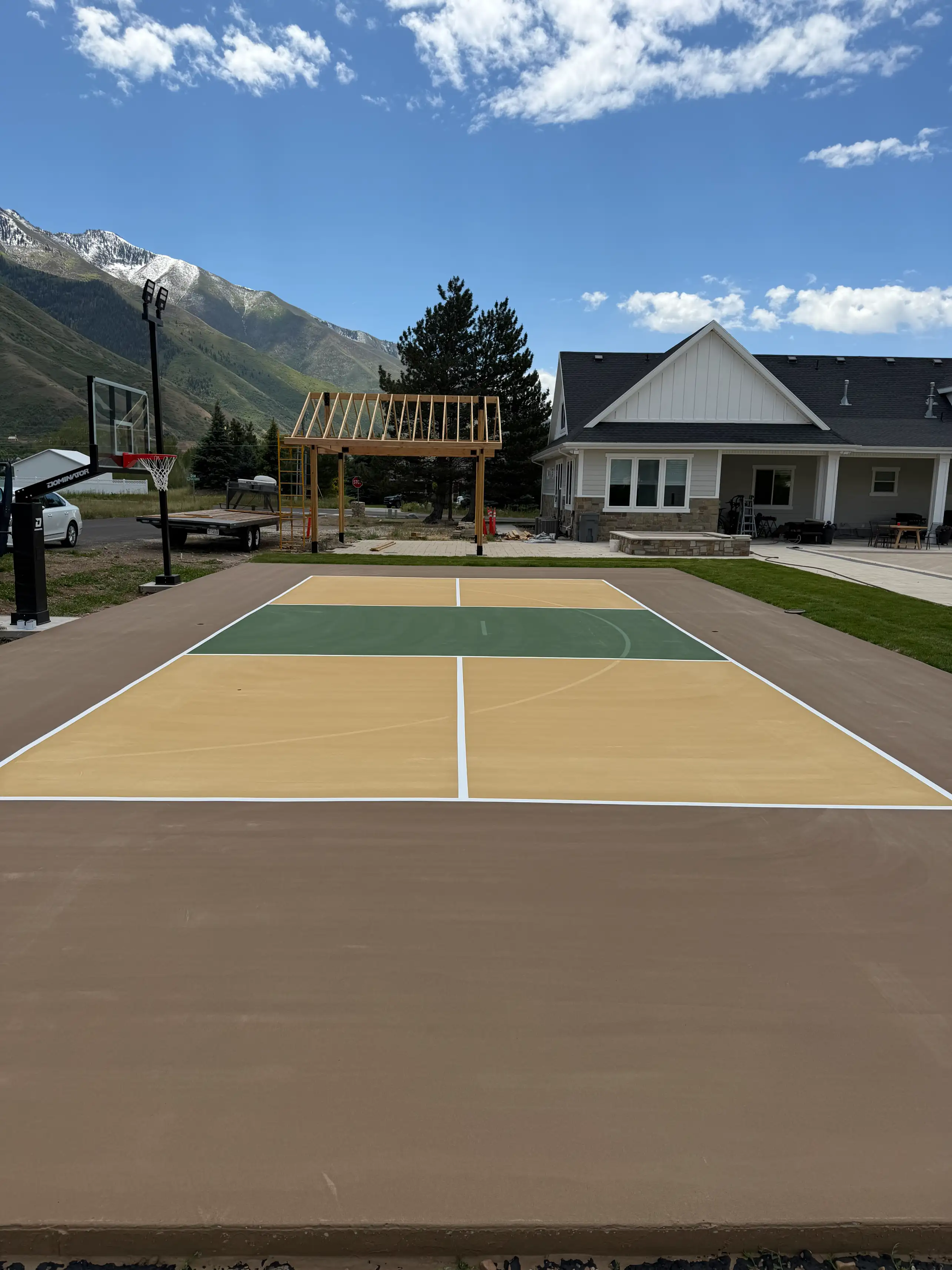 Brown, tan and green multicourt below snow-capped mountains