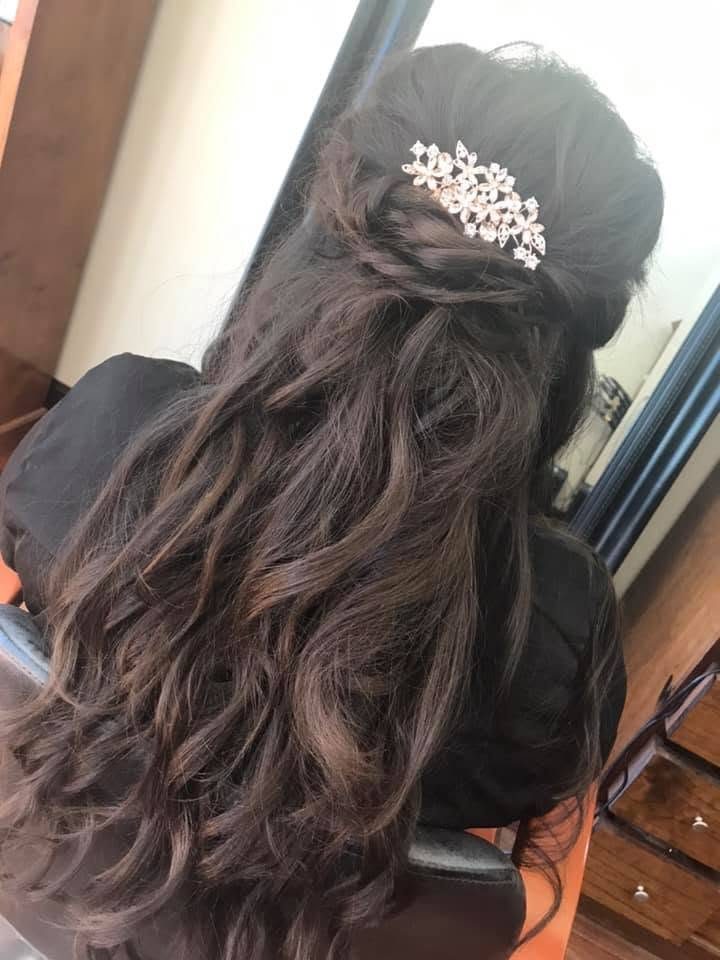 Long dark waves styled half up with a jeweled floral comb