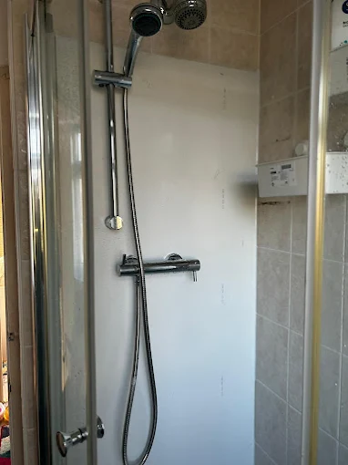 Plumber carrying out shower repairs and installation
