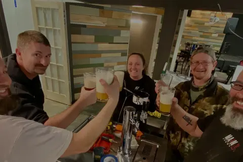 Guests raising a toast at the bar in the Main Event Club Room