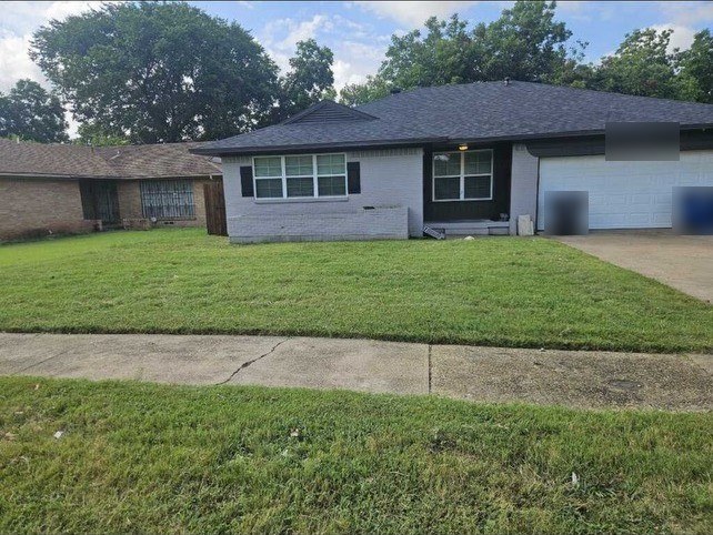 Front view of a single-story house with a two-car garage and a lawn. Representative photo of a different property, not the Oak Street sample.