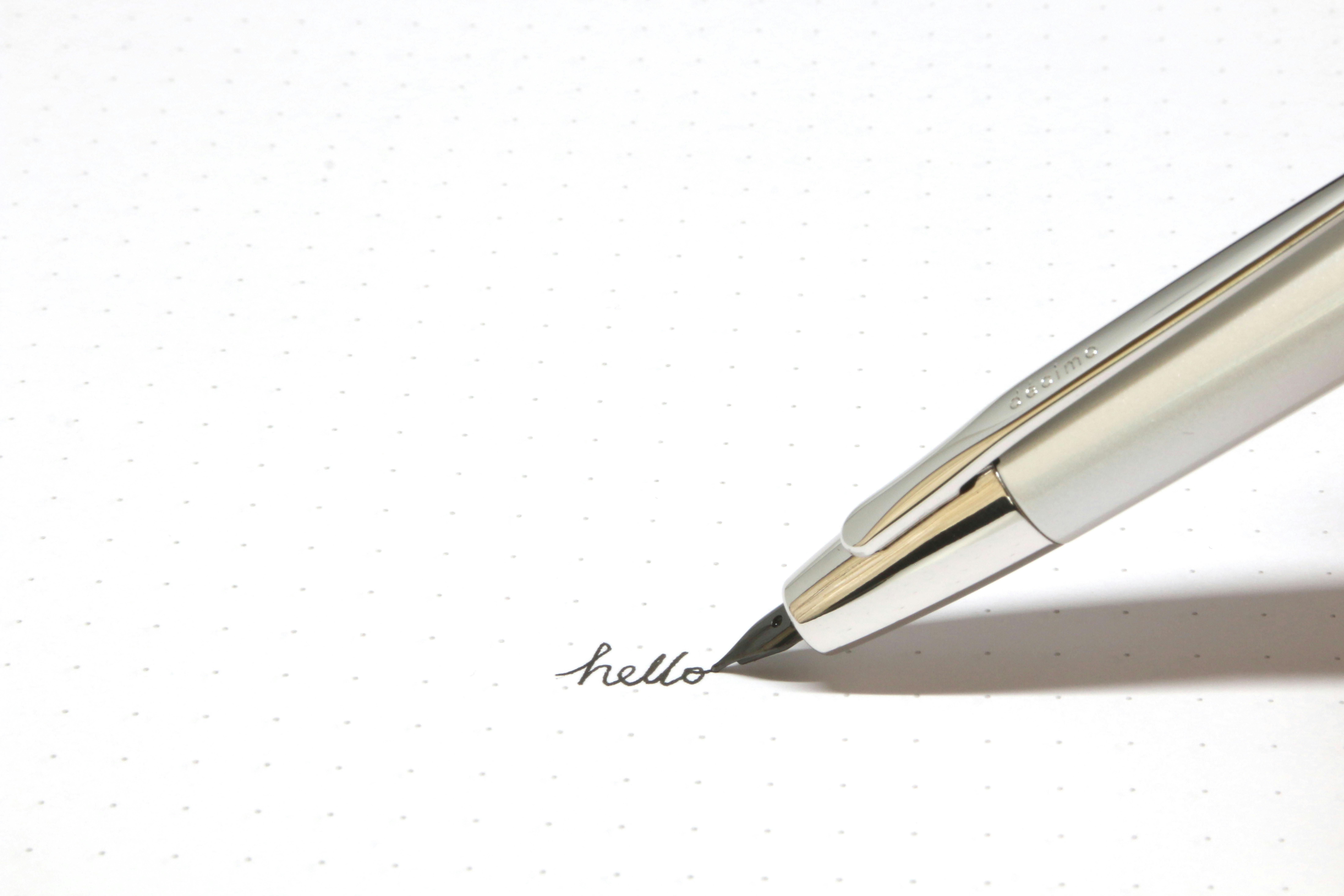 Pen writing hello on paper