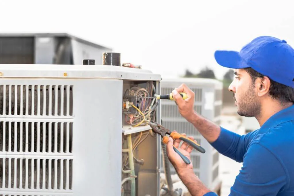 Técnico reparando una unidad exterior de HVAC