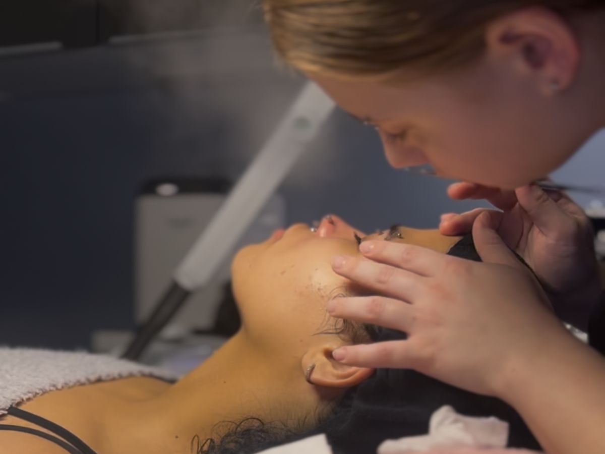 Esthetician examining a client's skin up close during a Signature Facial at Ambiance Spa in Houston