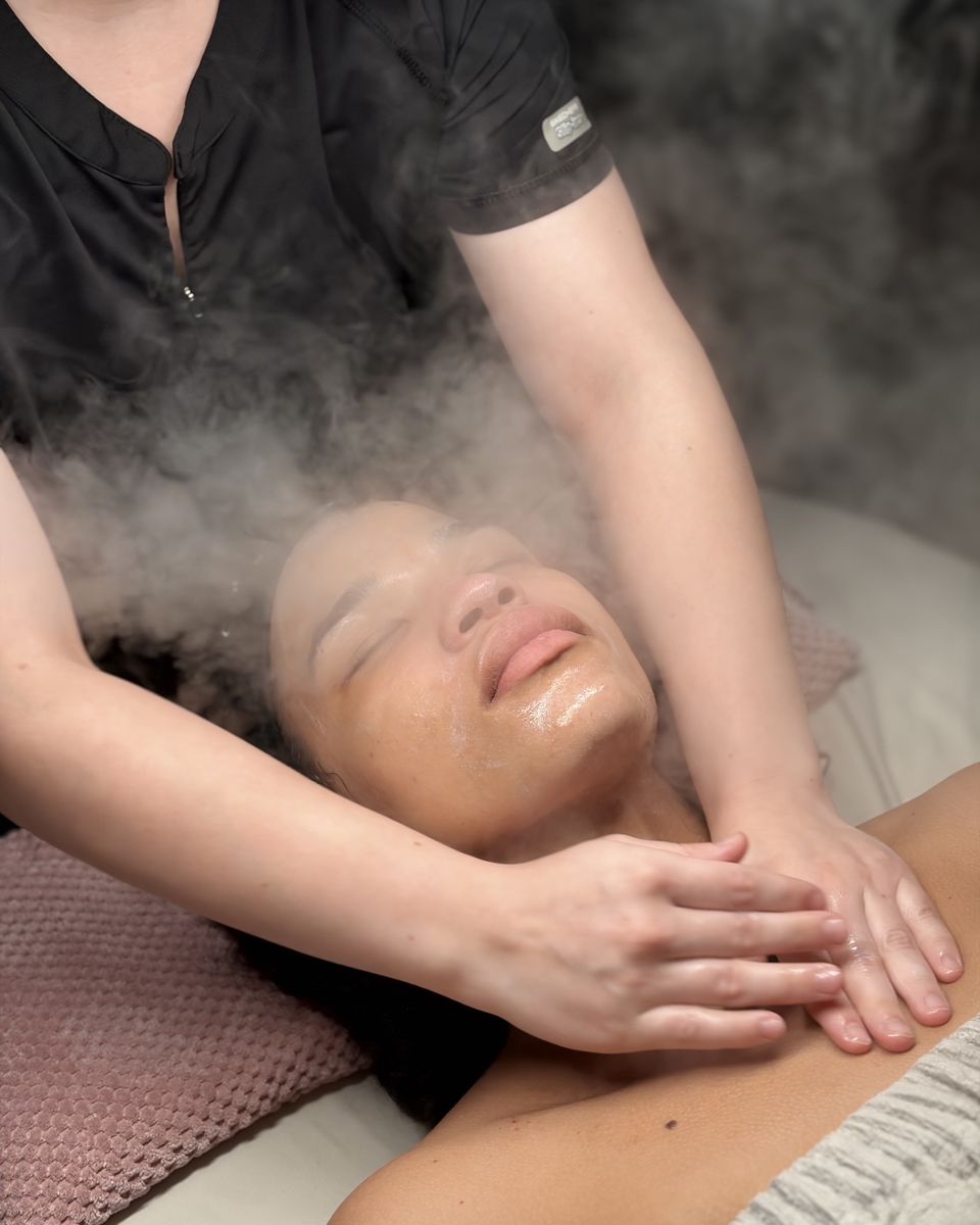 Esthetician giving a neck and shoulder massage under steam during a Signature Facial at Ambiance Spa in Houston