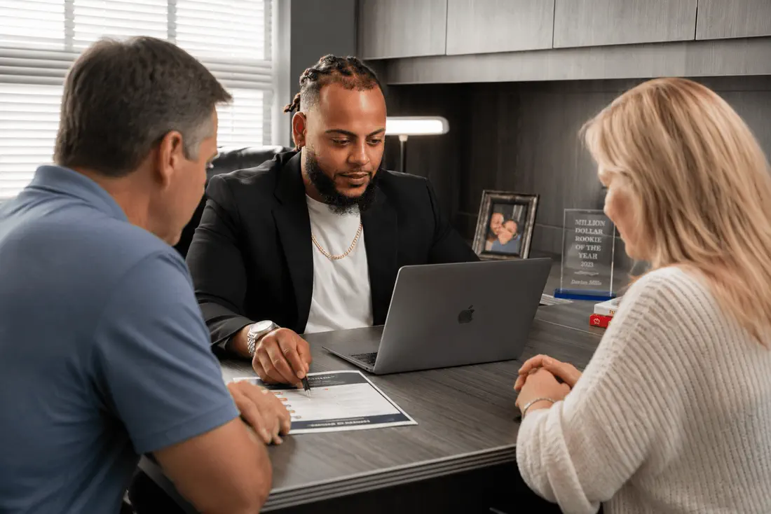 Darius Mills reviewing health insurance plan options with two clients