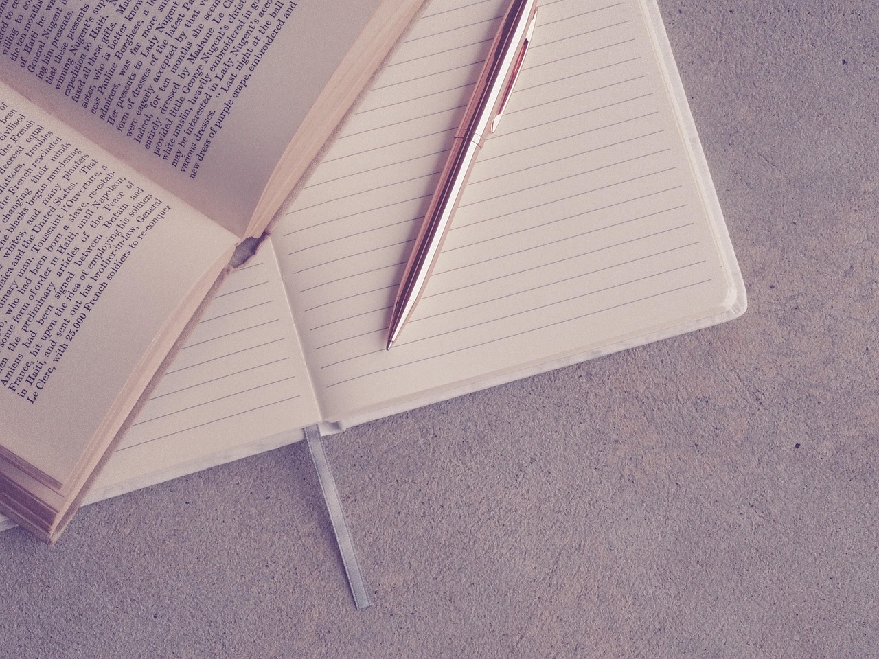 A pen resting on a journal of handwritten notes.