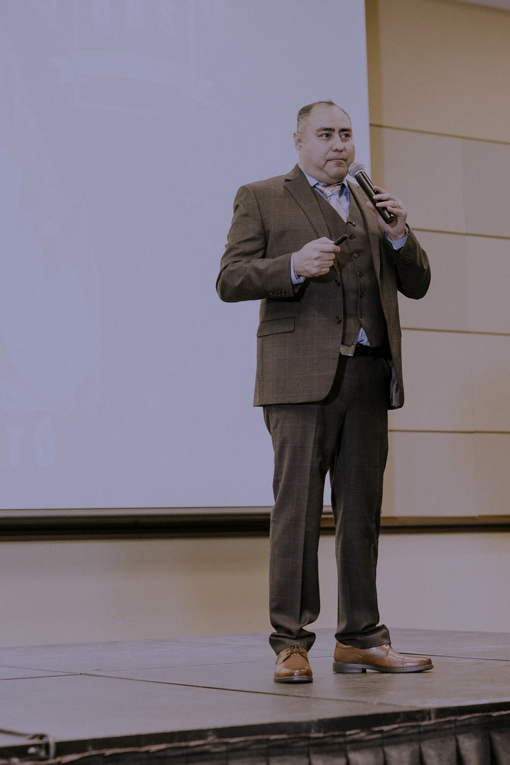 Alfredo Olvera dando una conferencia con micrófono en mano.