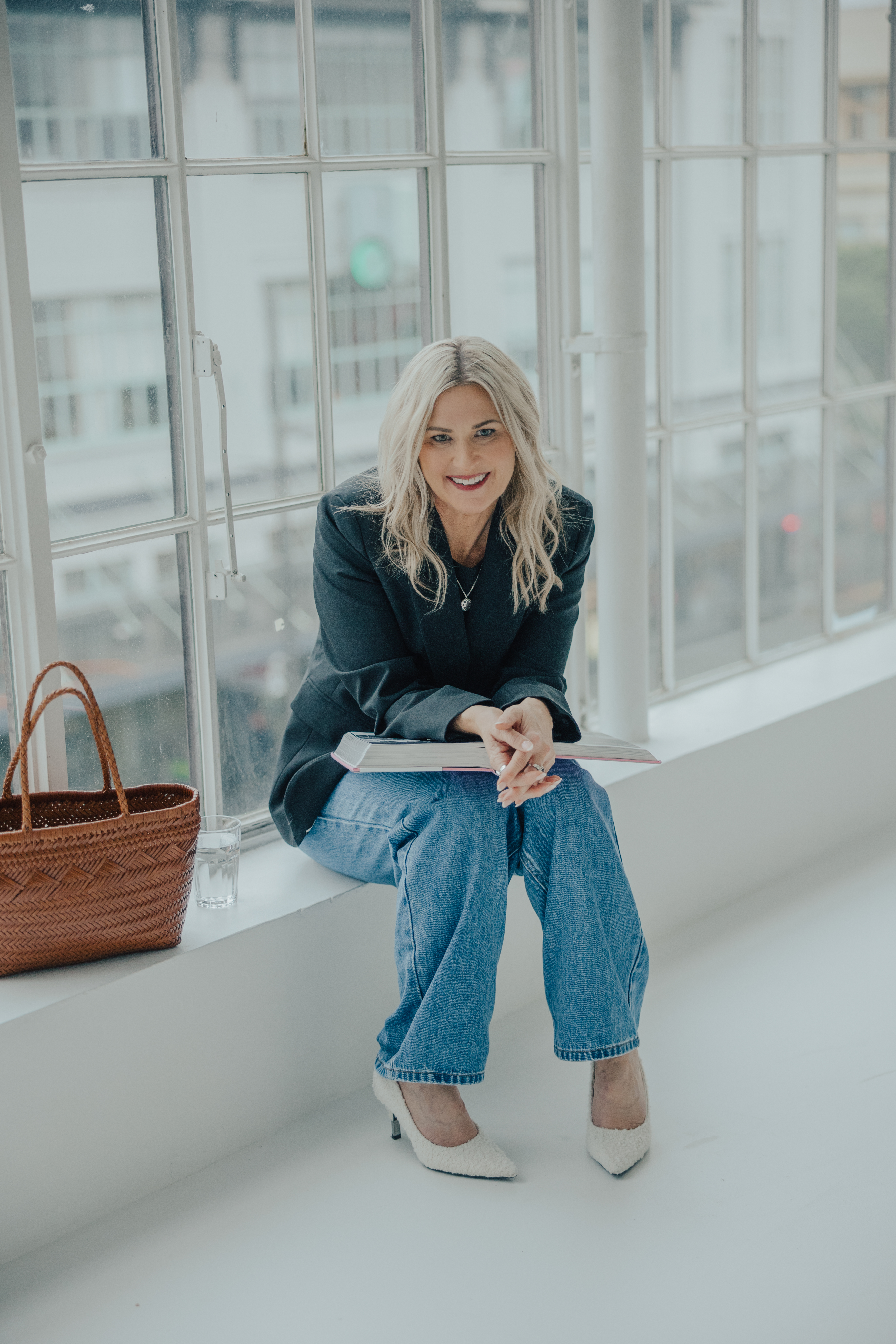 Melissa Armitage Auckland personal stylist sitting by window with fashion book
